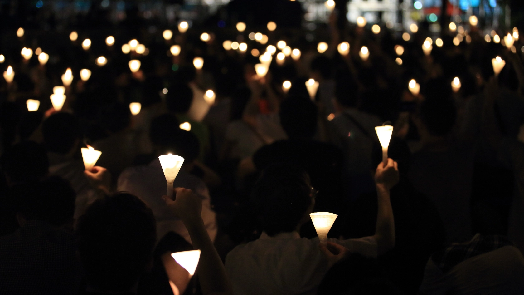 finding the light in dark. a haza candlelight vigil find each other in darkness, blur background in hong kong victoria park