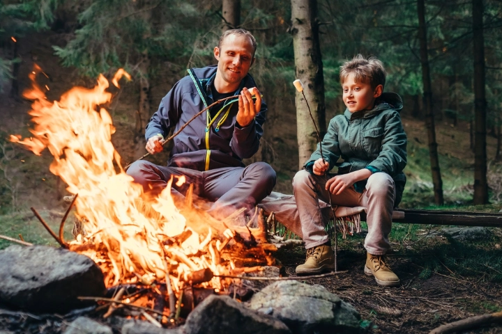 Vater und Sohn gemeinsam beim Marshmellowgrillen am Lagerfeuer